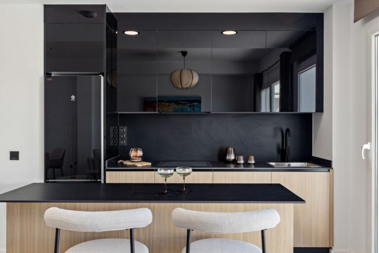 Show apartment kitchen with island and black cabinetry